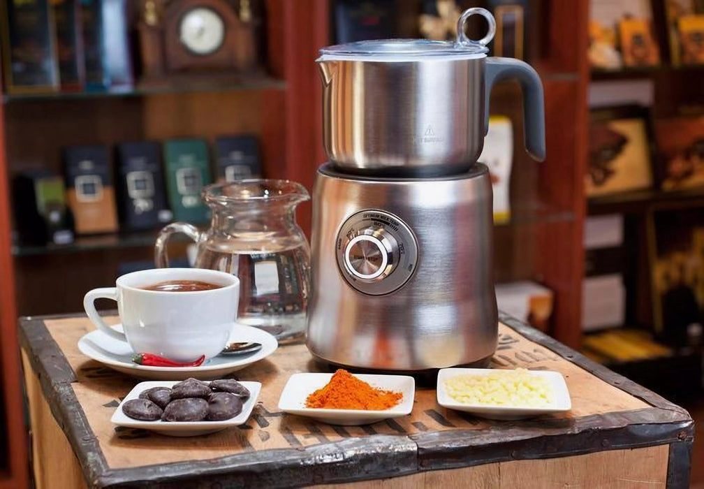 Mælkeskummer fra Sage som står på et bord sammen med en kop kaffe.